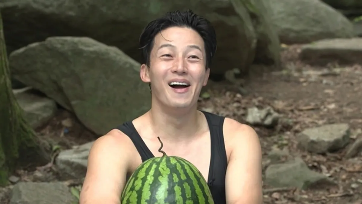 Heo Kyung-hwan sonríe mientras abraza una sandía en el bosque de Manisan