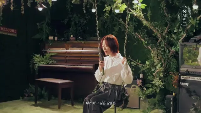 Annyeong-hasin-ga-yeong Sings Amidst a Lush Green Forest Set