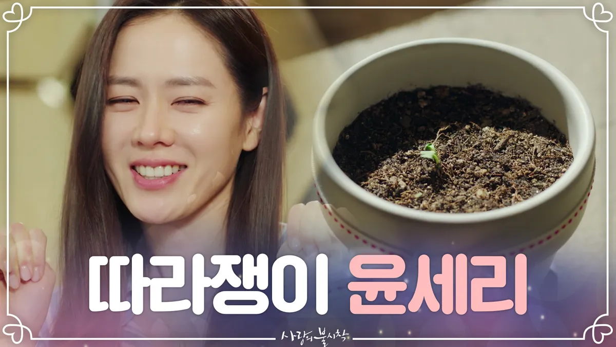 Son Ye-jin smiles while gazing at a small flowerpot in a scene from the drama 'Crash Landing on You'
