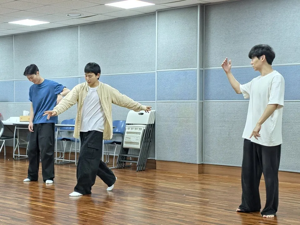 Performers practice dance movements 30 minutes before the show