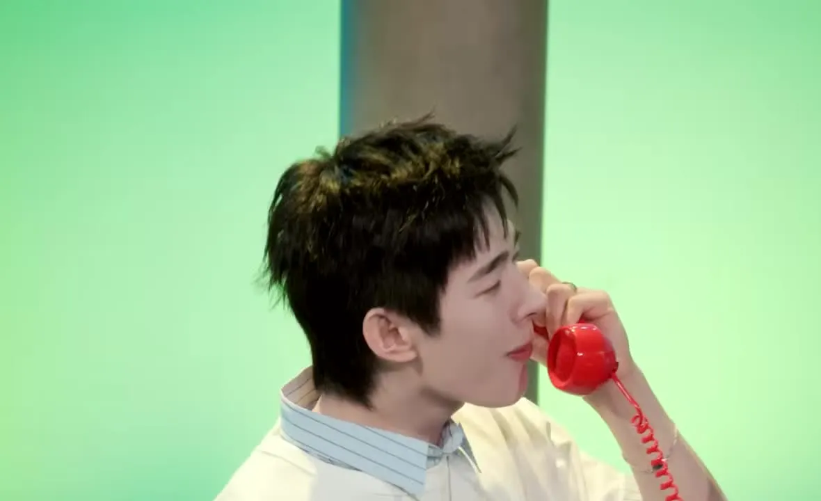 Tomoya de NEXZ aparece cantando con un auricular rojo en su video de mini concierto oficial