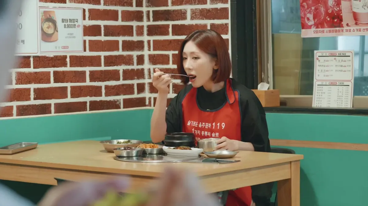 A scene of someone wearing an apron and eating food at a restaurant