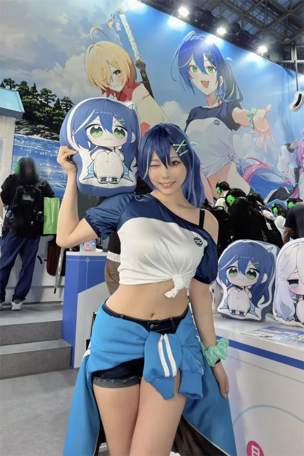 Model Umi Shinonome poses cutely with 'Nika' cushion from Pearl in Blue at Netmarble booth during TGS 2026