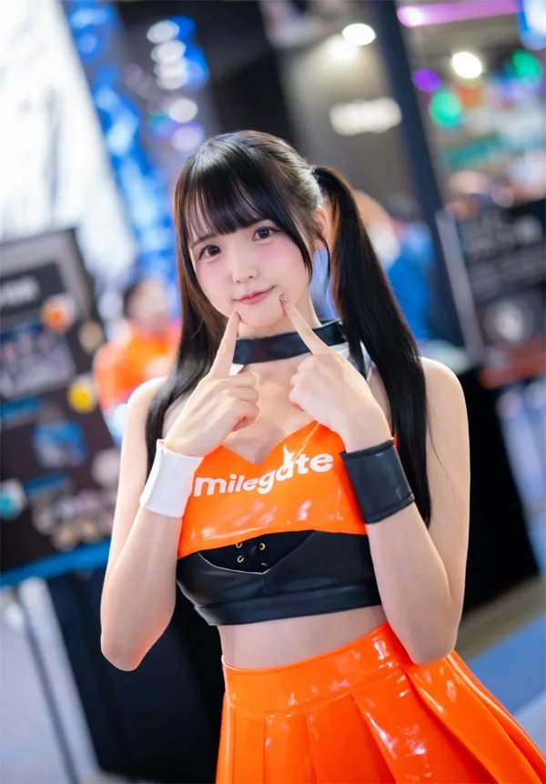 Model Mizuumi Ramune smiles cutely while posing with her fingers pressing against her cheeks at the…
