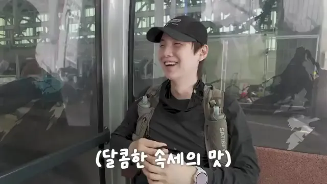 Suga talks while wearing gear ahead of his Swiss mountain hike