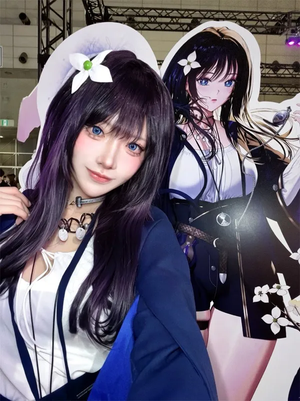 Official model Yukimura poses for a selfie next to a life-size panel of the character 'Ende' from…