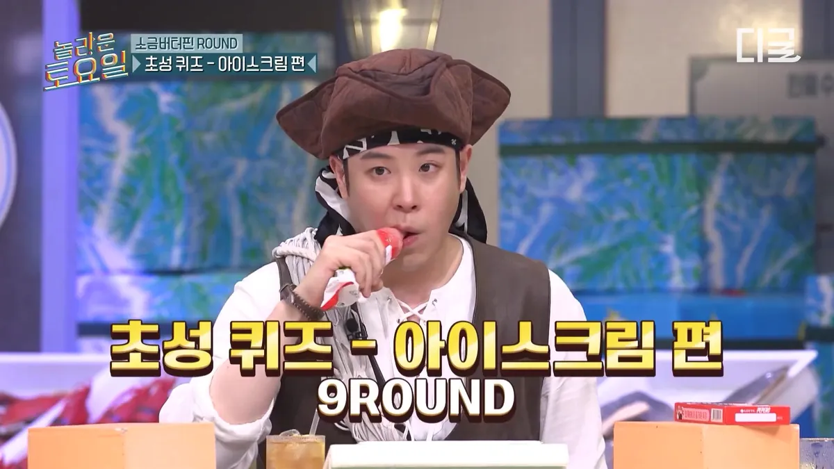 A man wearing a pirate hat is eating ice cream