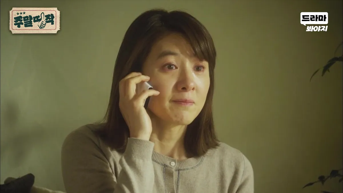 Yoon Seol holding a mobile phone with a sorrowful expression