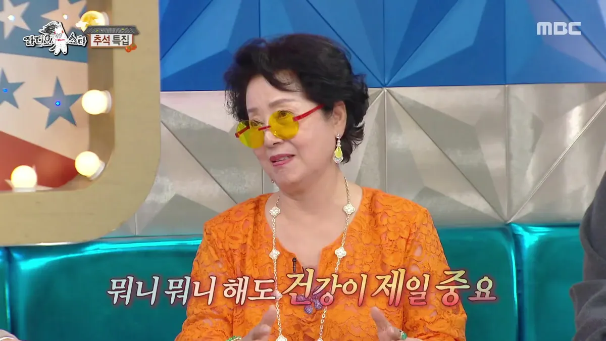 Sunwoo Yong-nyeo smiles brightly in an orange outfit
