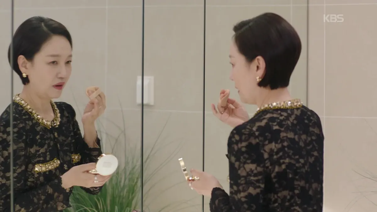 Ahn Hee-yeon applying makeup while looking in the mirror