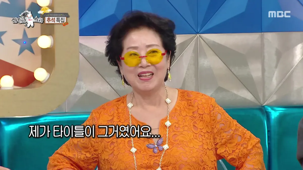 Sunwoo Yong-nyeo Smiles in Orange Outfit and Yellow Sunglasses