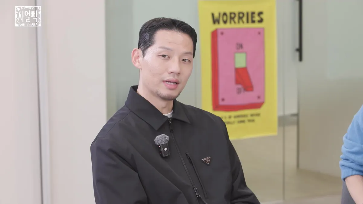 A man in a black jacket stares straight ahead
