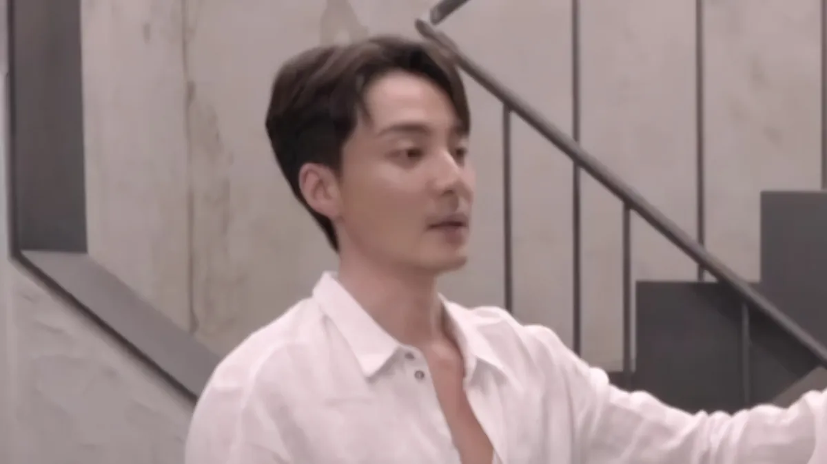 A man in a white shirt is indoors