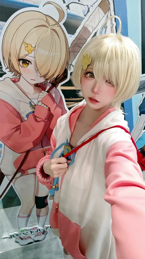 Model Kitaro takes a shy selfie right next to a Yotsuba character panel