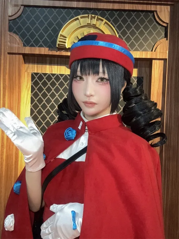 Model Anzai Rin poses in front of an elevator wearing an outfit featuring a hat, a cape, and blue rose decorations